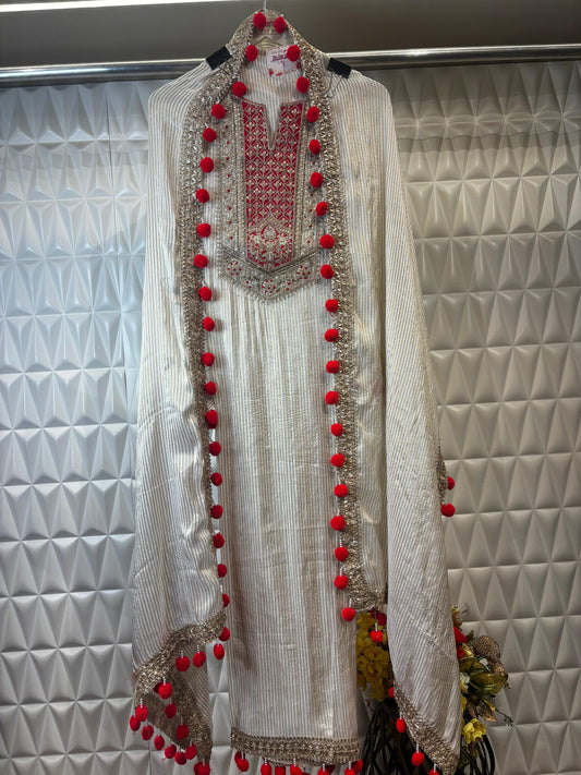 This sophisticated off-white suit showcases exquisite golden zari work