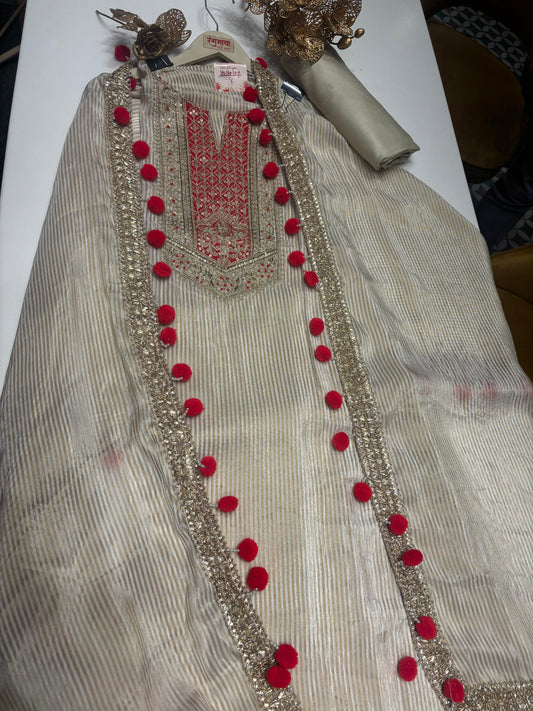 This sophisticated off-white suit showcases exquisite golden zari work