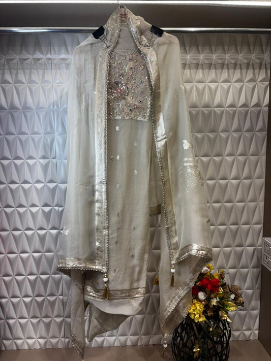 An elegant organza tissue suit featuring a beautifully hand-embroidered neckline